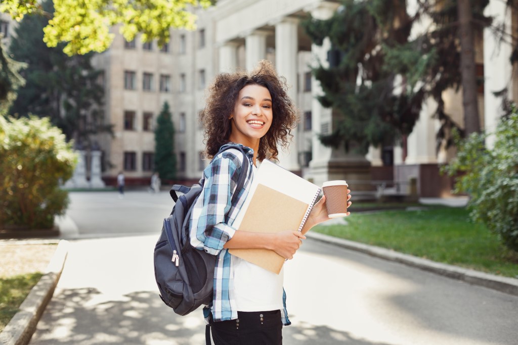 student girl with backpack, coffee and folders and worksheets