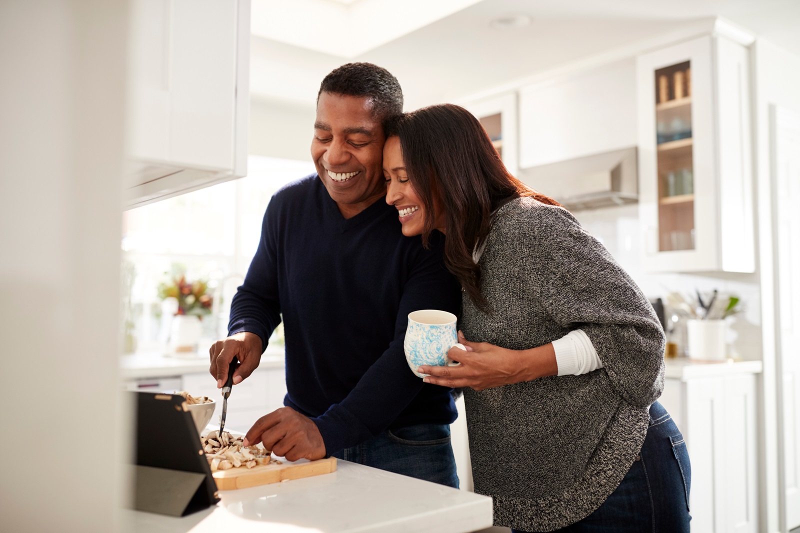 A middle-aged couple making dinner together in their kitchen.