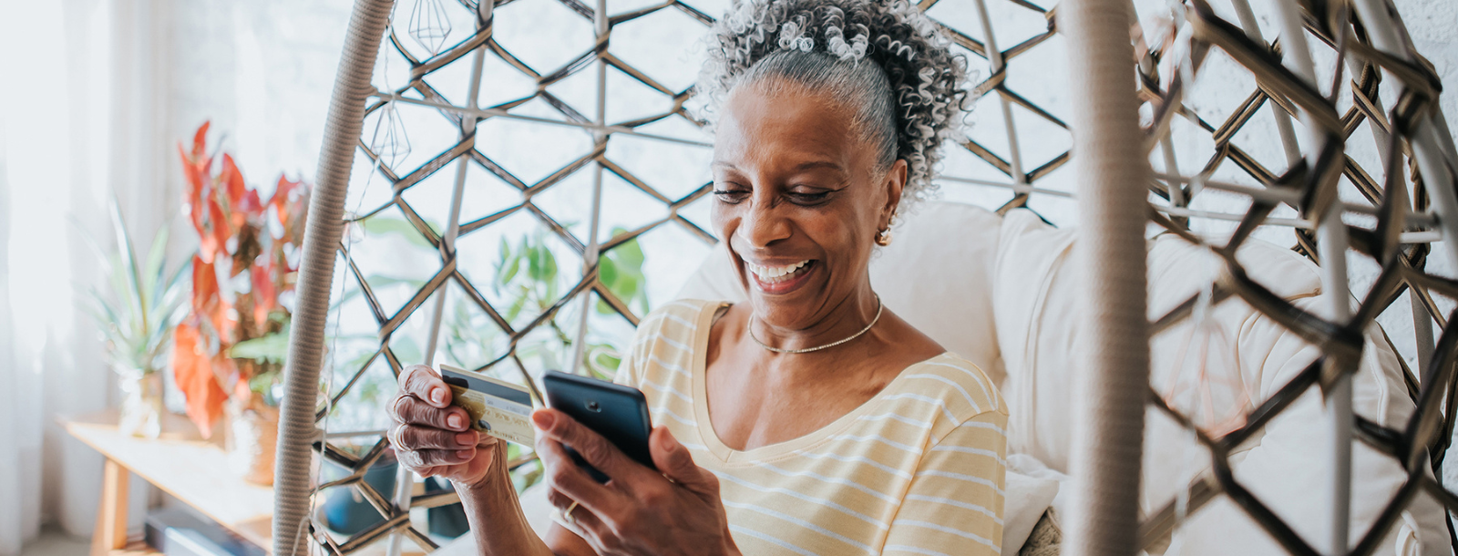 Woman looking at credit card and phone. 